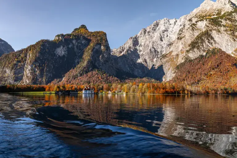 Königssee im Herbst mit bunten Laubwäldern und Felswänden