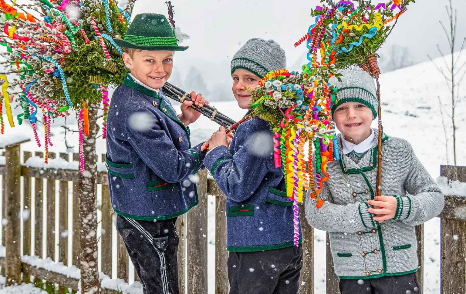 Buben in Tracht mit bunten Palmbuschen am Palmsonntag in Oberau