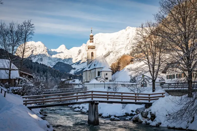 Pfarrkirche St. Sebastian in Ramsau im Winter mit verschneitem Steg