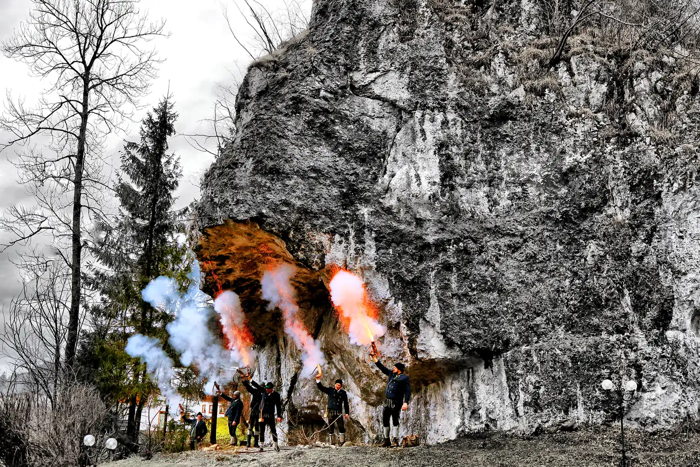 Weihnachtsschützen mit Pulverdampf beim Böllerschießen an einer Felswand